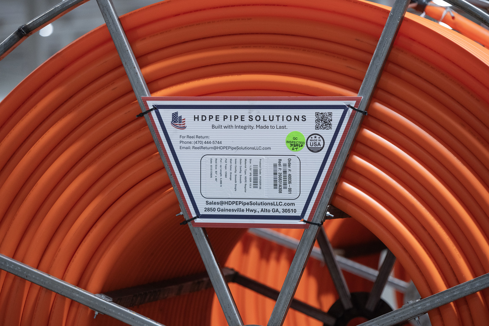 A finished reel of orange HDPE conduit with its branded order label